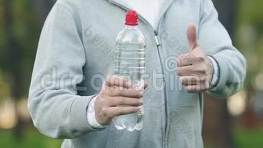 运动<strong>健将</strong>手举大拇指的饮料瓶，每日取水